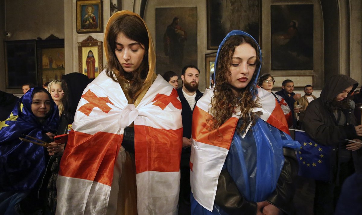 Gruusia ja EL-i lippudesse mähitud noored 4. aprillil meeleavalduste vaheajal Thbilisi Püha Kolmainu katedraalis lihavõtte-eelsel jumalateenistusel  