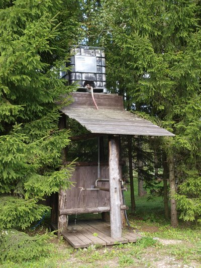 Peep Paimre ehitas oma talu külalistele palkidest ja laudadest lihtsa varjualuse, mille alla mahub kolm pesemiskohta ning mida varustab veega katusele tõstetud suur veepaak. 