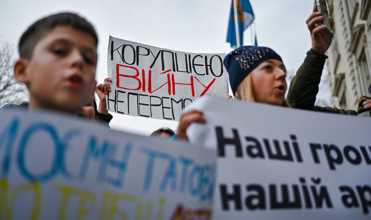 Lvivis toimunud meeleavaldus, millega kutsuti üles kärpima mittekriitilisi eelarvekulutusi ja andma raha Ukraina sõjaväele. Üks meeleavaldaja hoiab käes plakatit „Korruptsiooniga sõda ei võida“. Foto tehtud 3. novembril 2023