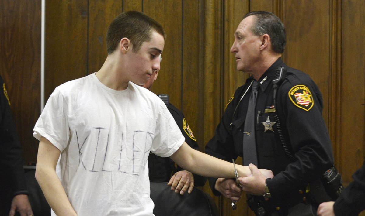 T. J. Lane, wearing a white t-shirt with the words "Killer" spelled out, is handcuffed by a sheriff's deputy after sentencing in Cleveland in this file photo