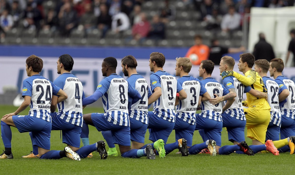 Berliini Hertha mängijad Schalkega peetud kohtumise eel põlvitamas.