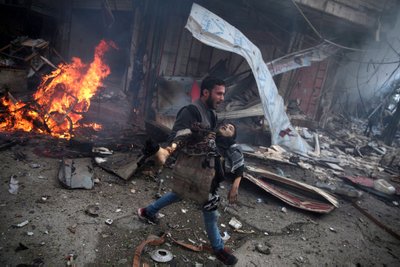 Süüria mees kannab lapse surnukeha, kes hukkus valitsuse õhuväe korraldatud rünnakus. Pildistatud 7. novembril 2015.
