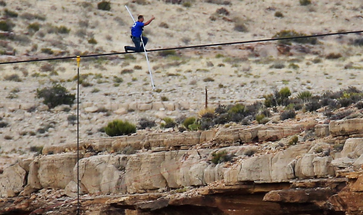 Daredevil Wallenda gives a thumbs-up sign as he nears the end of a steel cable rigged across more than a quarter-mile deep remote section of the Grand Canyon near Little Colorado River