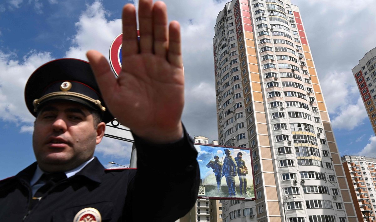 Сотрудник полиции охраняет территорию возле поврежденного многоэтажного жилого дома после сообщения об атаке беспилотника в Москве 30 мая 2023 года.