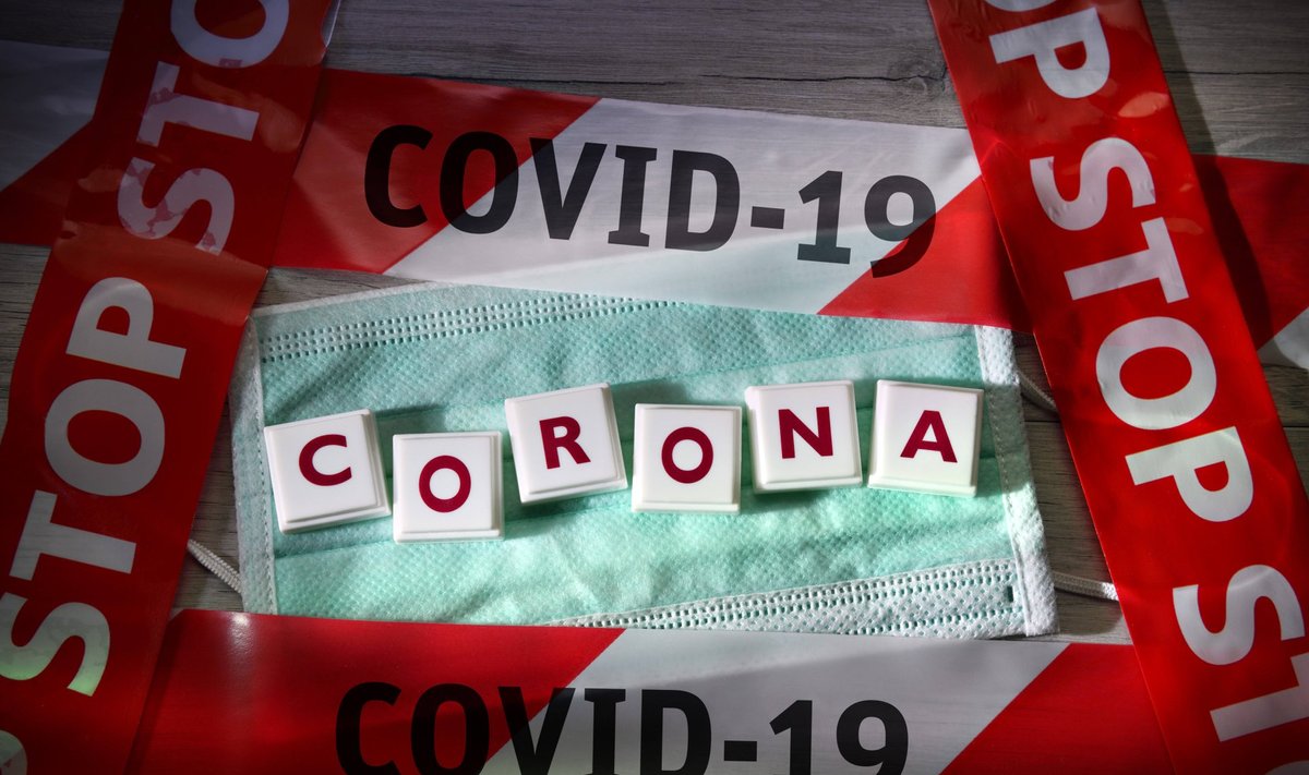 Corona-Schriftzug auf Mundschutz und Absperrband, Symbolfoto Coronavirus *** Corona lettering on face mask and barrier t