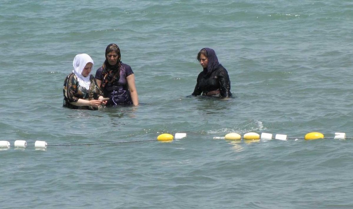 Iraani naised Kaspia meres suplemas. Noored naised püüavad karme reegleid ja nende täitmist jälgivat moraalipolitseid üha enam proovile panna. Rätid vajuvad kuklasse, musta värvi vahele seguneb erksamat, kehajooni hägustava tuunika serv tõuseb maast üha kõrgemale. Ning nelja seina vahel kantakse läänelikke rõivaid. (Foto: Kadri Ibrus)