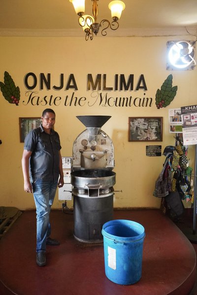 Kohvik/röstikoda Moshi linnas – Union Coffee. Fotol kohalik röstimismeister röstimismasinaga, mida kohvikus kasutatakse.