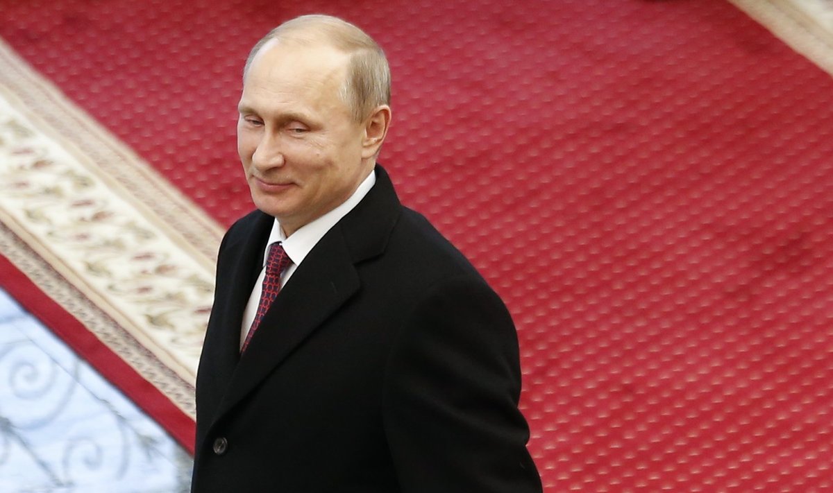 Russian President Vladimir Putin reacts after peace talks on resolving the Ukrainian crisis in Minsk