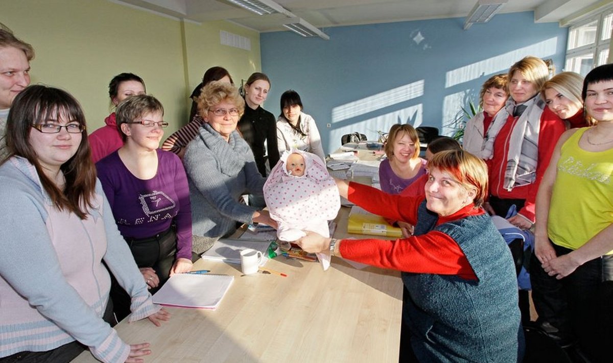 Lastehoiu eriala õpilased õpivad beebiga hakkama saamist, õpilaste keskel hoiab õppenukku käes kooli direktor Hele Angerjärv.