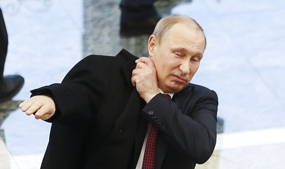 Russian President Putin puts on his coat after peace talks on resolving the Ukrainian crisis in Minsk