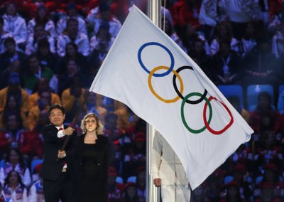 Pyeongchang Mayor Sok-ra waves the Olympic flag during the closing ceremony for the Sochi 2014 Winter Olympics