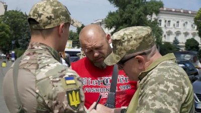 Офицеры мобилизационного патруля Анатолий (справа) и Алексей (слева) проверяют, внес ли остановленный ими мужчина свое имя в базу данных