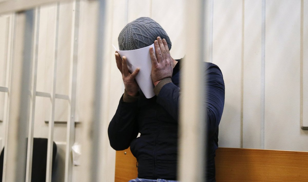 Kahtlustatavana kinni peetud Anzor Gubašev peidab oma nägu fotograafide eest.
