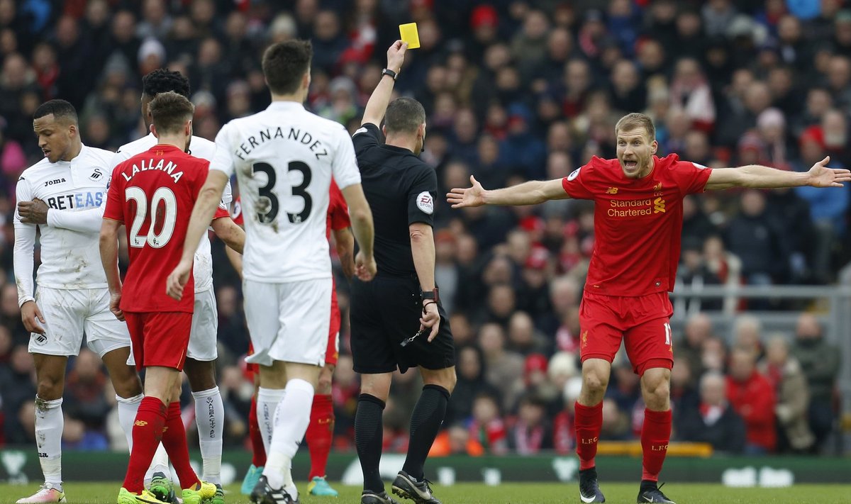 Liverpool's Ragnar Klavan is shown a yellow card by referee Kevin Friend