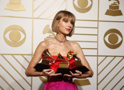 Taylor Swift poses with her awards during the 58th Grammy Awards in Los Angeles