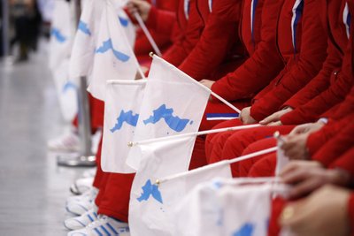 Korea poolsaart kujutavad lipukesed Põhja-Koreast pärit poolehoidjate käes.