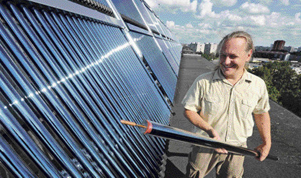 Mustamäe kortermaja innovaatiline ühistu esimees Jaanus Raudsepp näitab päikeseküttepaneelis kasutatavat vaakumtoru.