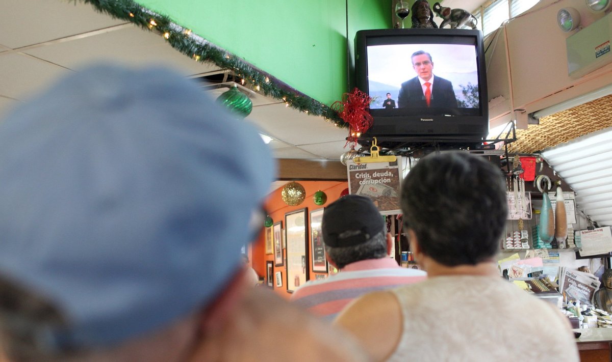 Kohvikus istuvad puertoricolased vaatavad telekast kuberner Alejandro Garcia Padilla pöördumist rahvale selle aasta detsembris.