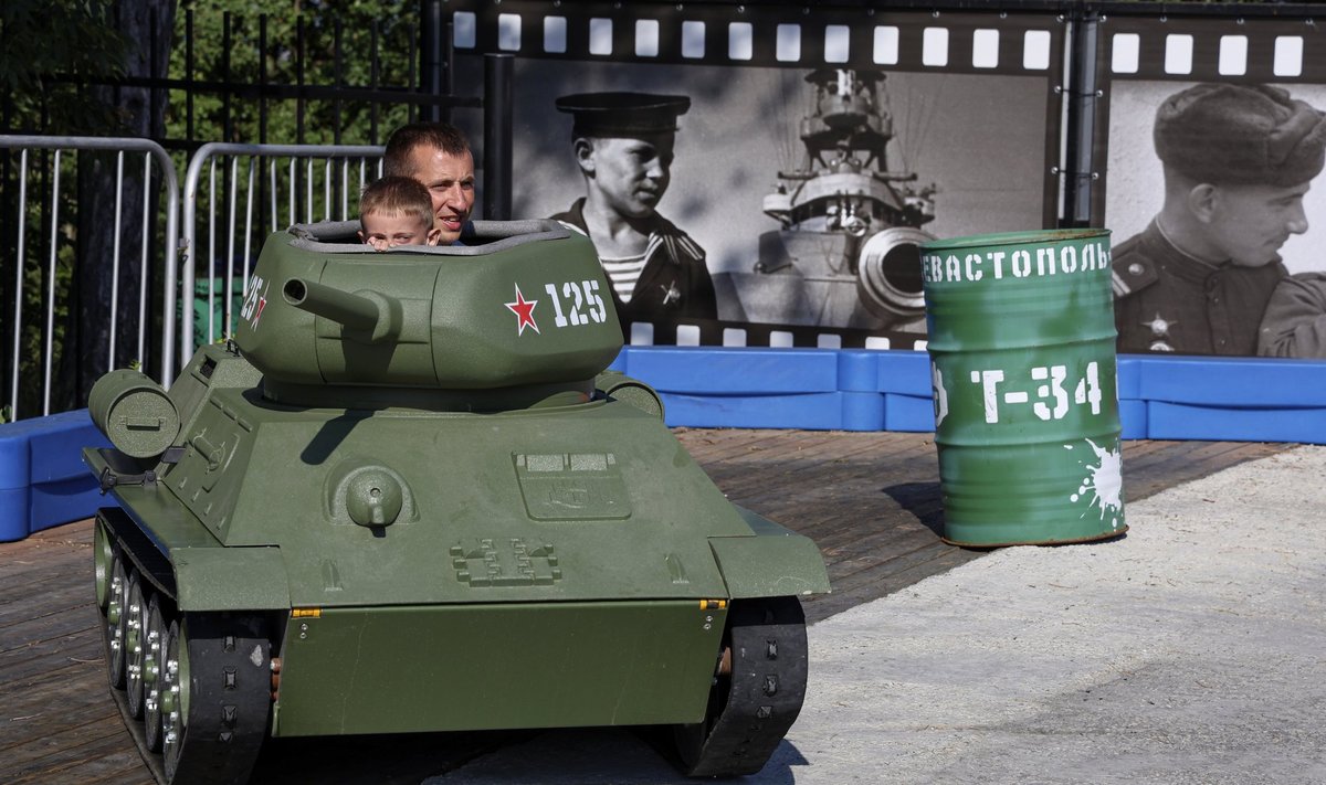 SEVASTOPOL: Tänavu 24. juulil klõpsatud pildil on isa ja poeg, kes külastavad Sevastopoli militaarmuuseumi ning teevad lõbusõitu Nõukogude Liidu teises maailmasõjas kasutatud tanki mudeliga.