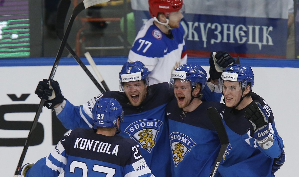Finland's Pakarinen celebrates with his team mates Kontiola Lajunen and Ohtamaa after scoring a goal against Russia during the first period of their men's ice hockey World Championship final game at Minsk Arena in Minsk