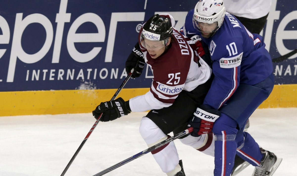 France's Meunier fights for the puck with Latvia's Dzerins  during their Ice Hockey World Championship game in Prague