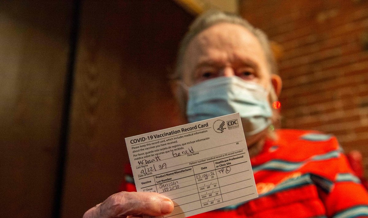 81-aastane USA veteran hoiab käes vaktsineerimiskaarti