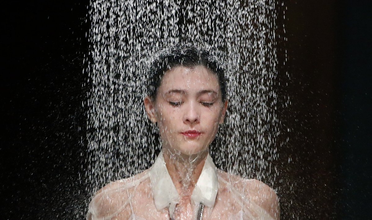Water falls on a model as she presents a creation by designer Hussein Chalayan as part of his Spring/Summer 2016 women's ready-to-wear collection show during the Fashion Week in Paris