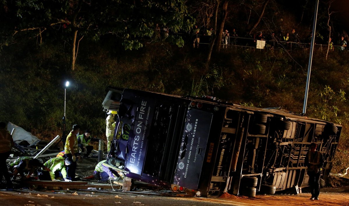 Rescuers walk beside a crashed bus in Hong Kong