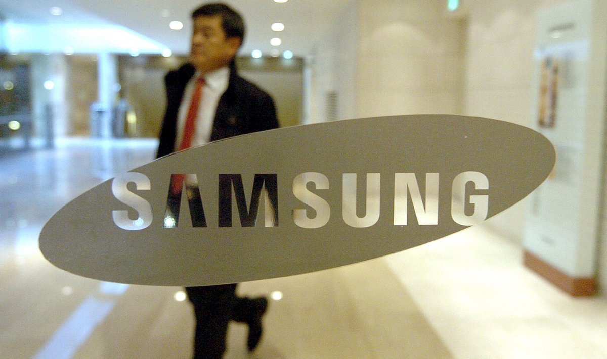 A man walks past a glass door showing a logo of Samsung Electronics at its main building in Seoul on January 29, 2010. South Korean giant Samsung Electronics said its annual earnings rocketed last year to more than eight billion USD thanks to post-crisis demand for flat-screen TVs and higher chip prices.  AFP PHOTO/PARK JI-HWAN