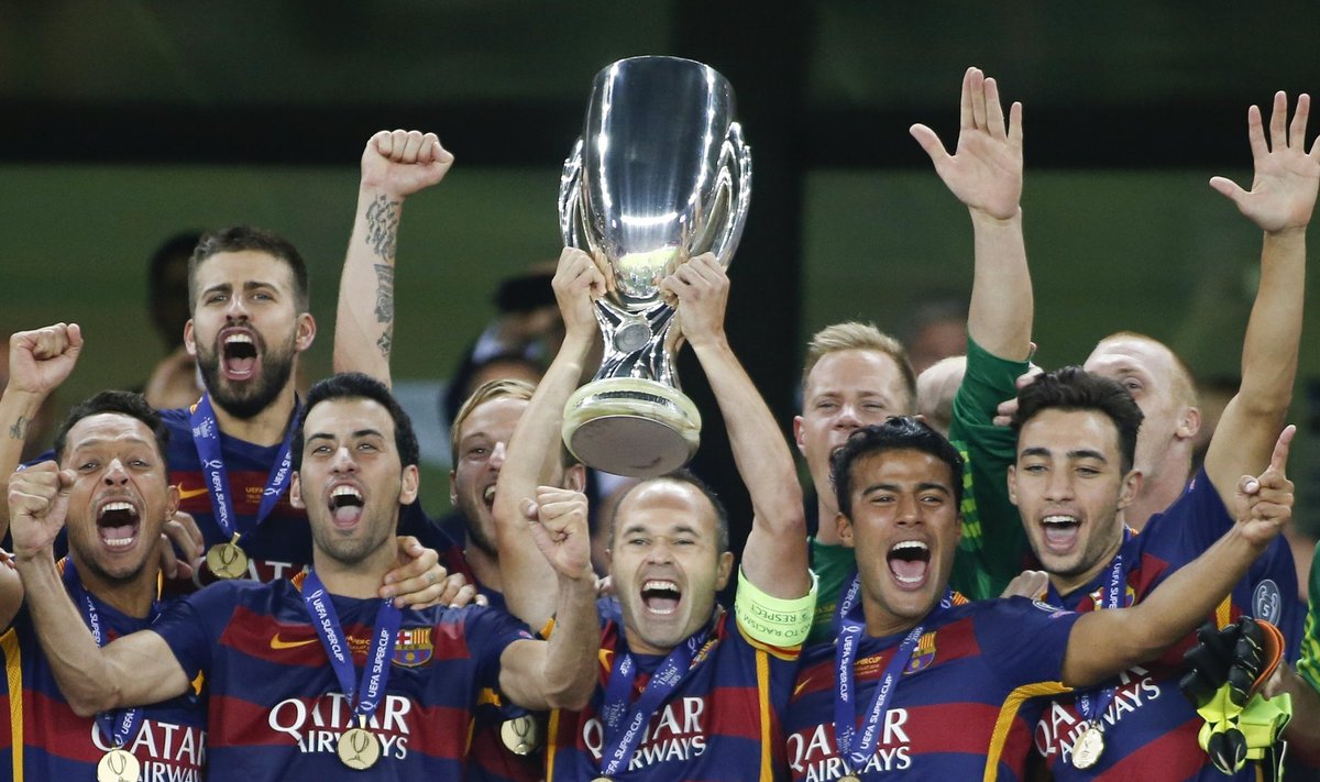 Barcelona's Andres Iniesta holds up the trophy near team mates as they celebrate their victory over Sevilla in the UEFA Super Cup soccer match at Boris Paichadze Dinamo Arena in Tbilisi