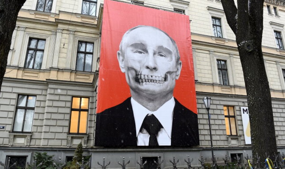 Баннер с изображением Владимира Путина напротив здания российского посольства в Риге