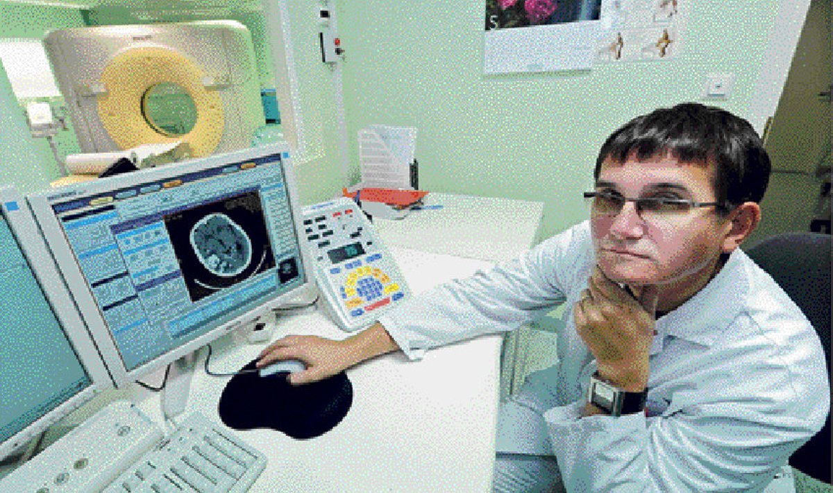 Ida-Tallinna keskhaigla neuroloogiaosakonna juhi Toomas Toomsoo ees arvutiekraanil on kompuutertomograafi tehtud pilt ajust, klaasseina taga aga väärt aparaat ise.