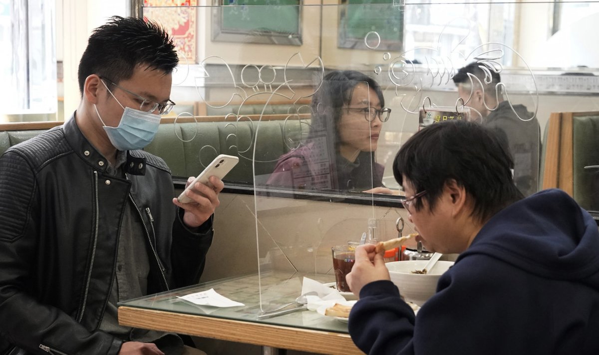Hetkeseis Hiinas Hongkongis: söögikohas lauajagajad on teineteisest plastikpaneeliga eraldatud, et vähendada võimalusi füüsiliselt kokku puutuda. (Foto: AP)