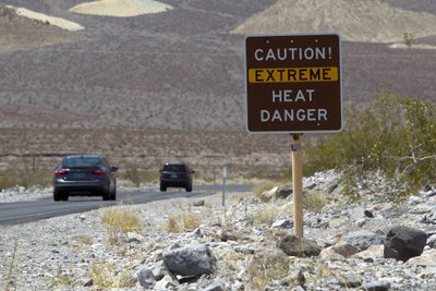 A sign warns of extreme heat as tourists enter Death Valley National Park in California
