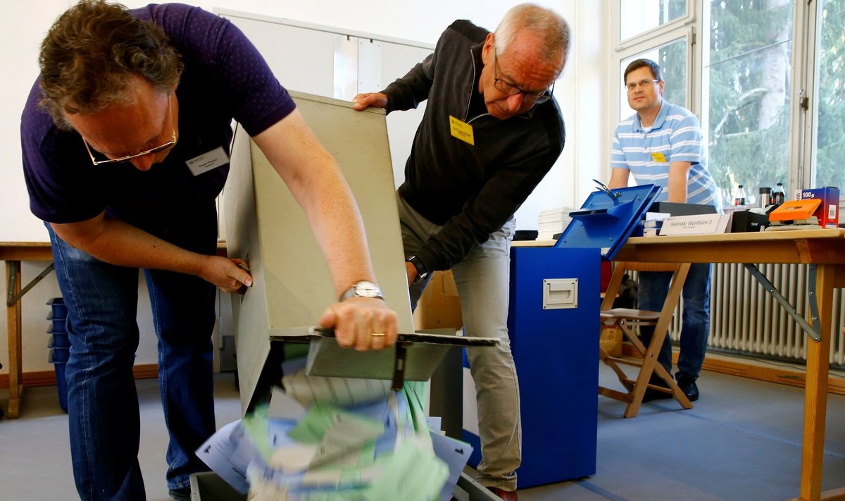 Members of the election office empty a ballot box in Zurich