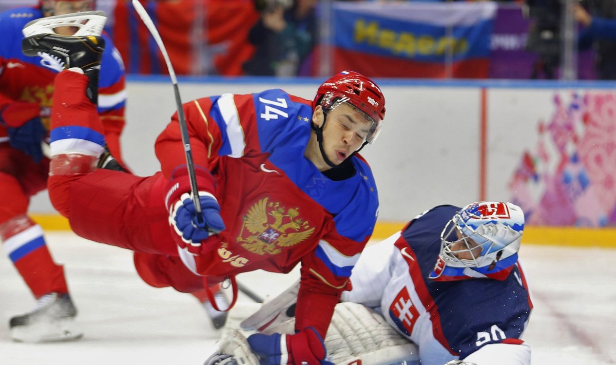 Russia's Alexei Yemelin hits Slovakia's goalie Jan Laco during the first period of their men's preliminary round ice hockey game at the Sochi 2014 Winter Olympic Games