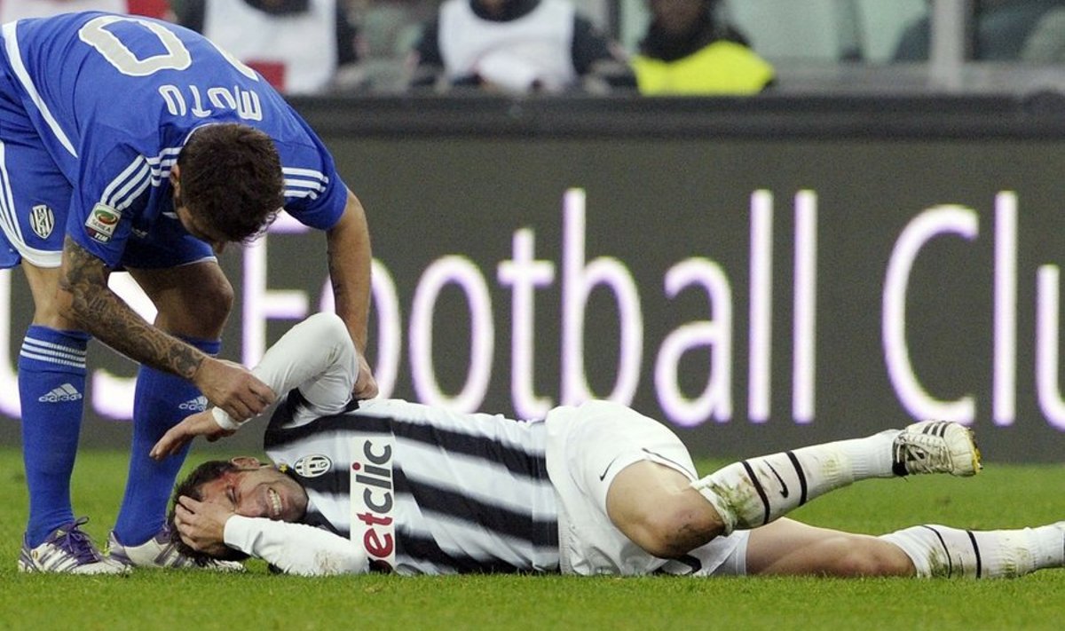 Del Piero pärast jalaga näkku saamist murul