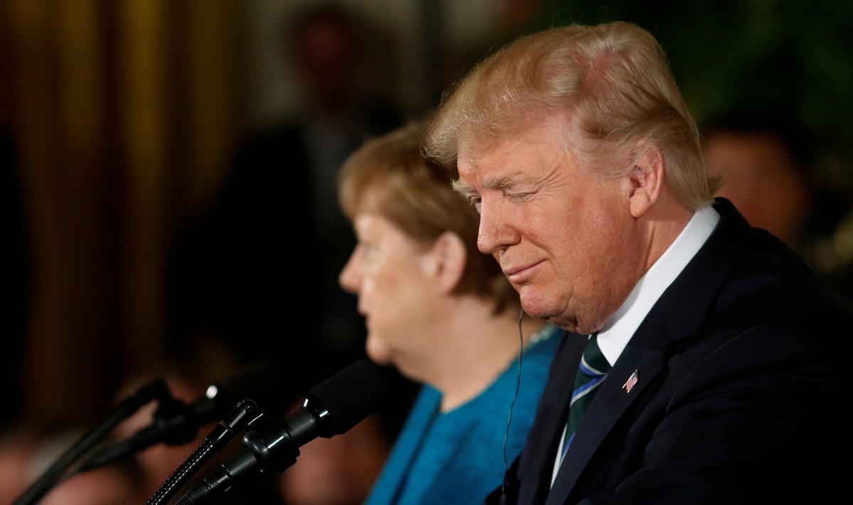 Trump winks at someone in the audience as he holds a joint news conference with Merkel in the East Room of the White House in Washington