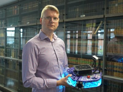 Karl Kruusamäe hoiab käes Tartu Ülikooli teadlaste ja üliõpilaste loodud õpperobotit Robotont