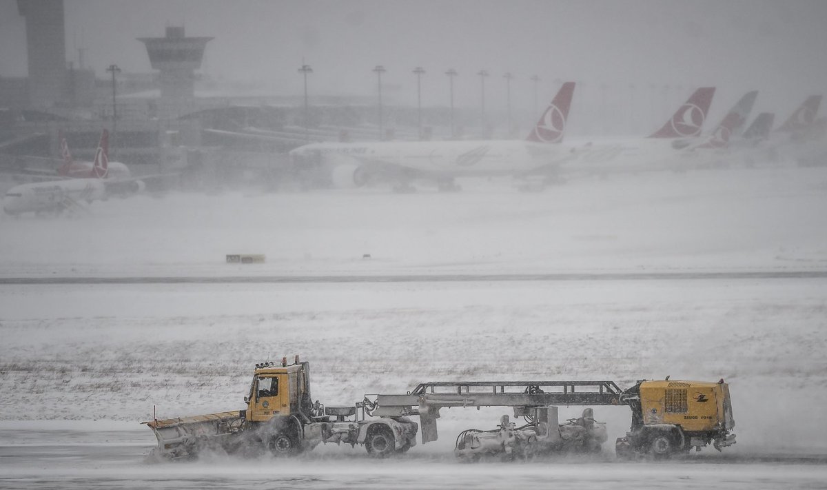 Lumesahad Atatürki lennujaamas töötamas 7. jaanuaril, tagaplaanil Turkish Airlinesi lennukid ilmaolude paranemist ootamas.