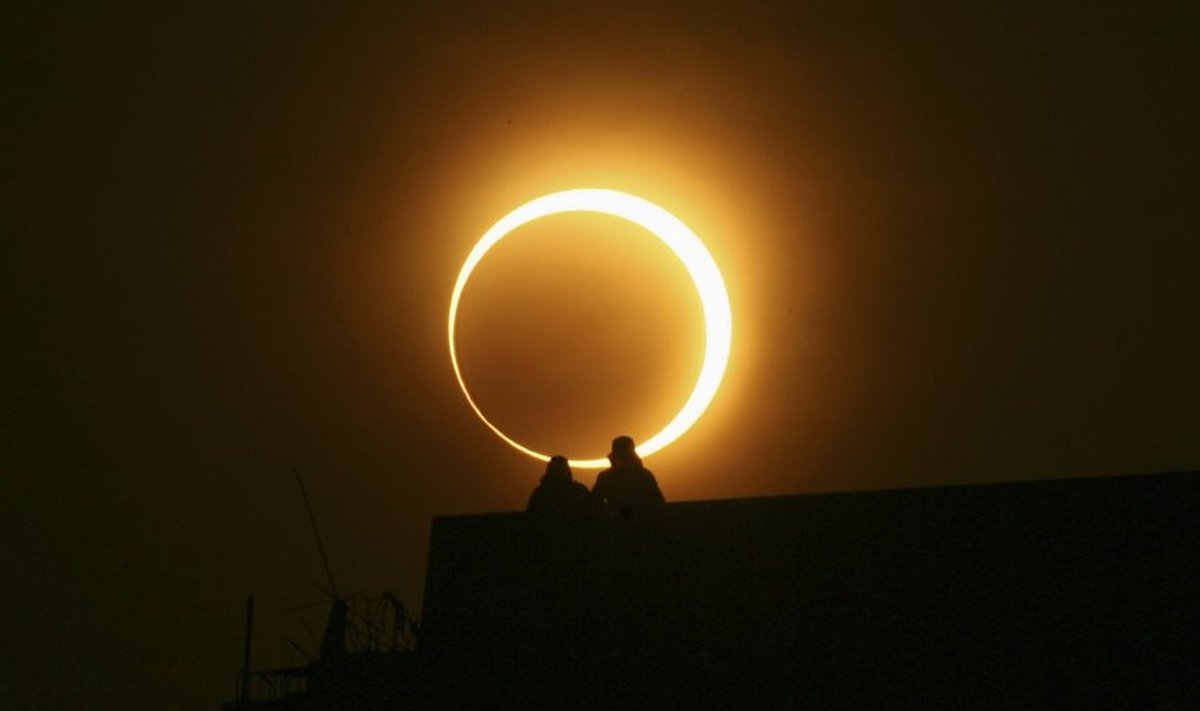 Two men sit on a bridge to watch an annular solar eclipse in Zhengzhou, Henan province, January 15, 2010. The longest, ring-like solar eclipse of the millennium started on Friday, with astronomers saying the Maldives was the best place to view the phenomenon that will not happen again for over 1,000 years. REUTERS/Donald Chan (CHINA - Tags: ENVIRONMENT SOCIETY)