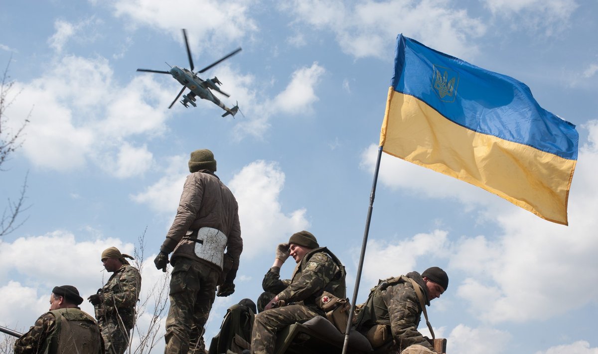 Десантники 25-й отдельной Днепропетровской аэромобильной бригады у Краматорска. В небе ударный вертолет Ми-24 с опознавательными знаками ВВС Украины.