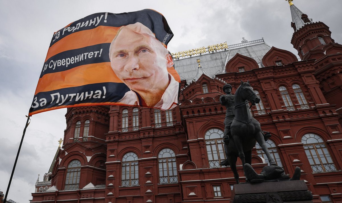 Флаг с изображением президента России Владимира Путина на площади перед Кремлем