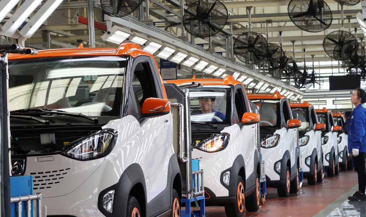 Hiina Bajouni autotehase töölised uusi E100 täiselektrilisi autosid inspekteerimas. 