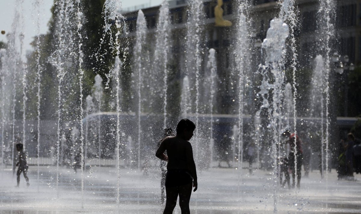 A child cools off in a fountain in Nice as a heatwave hits much of the country