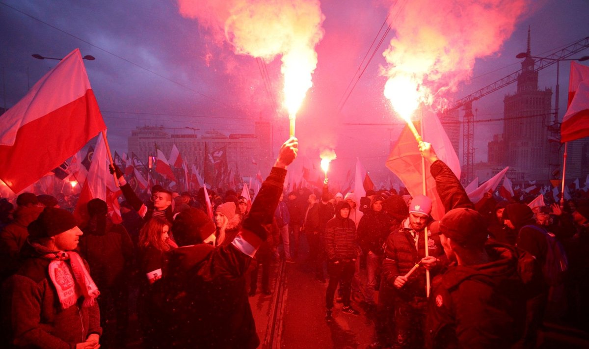 FILE PHOTO: Protesters light flares and carry Polish flags during a rally, organised by far-right, nationalist groups, to mark 99th anniversary of Polish independence in Warsaw