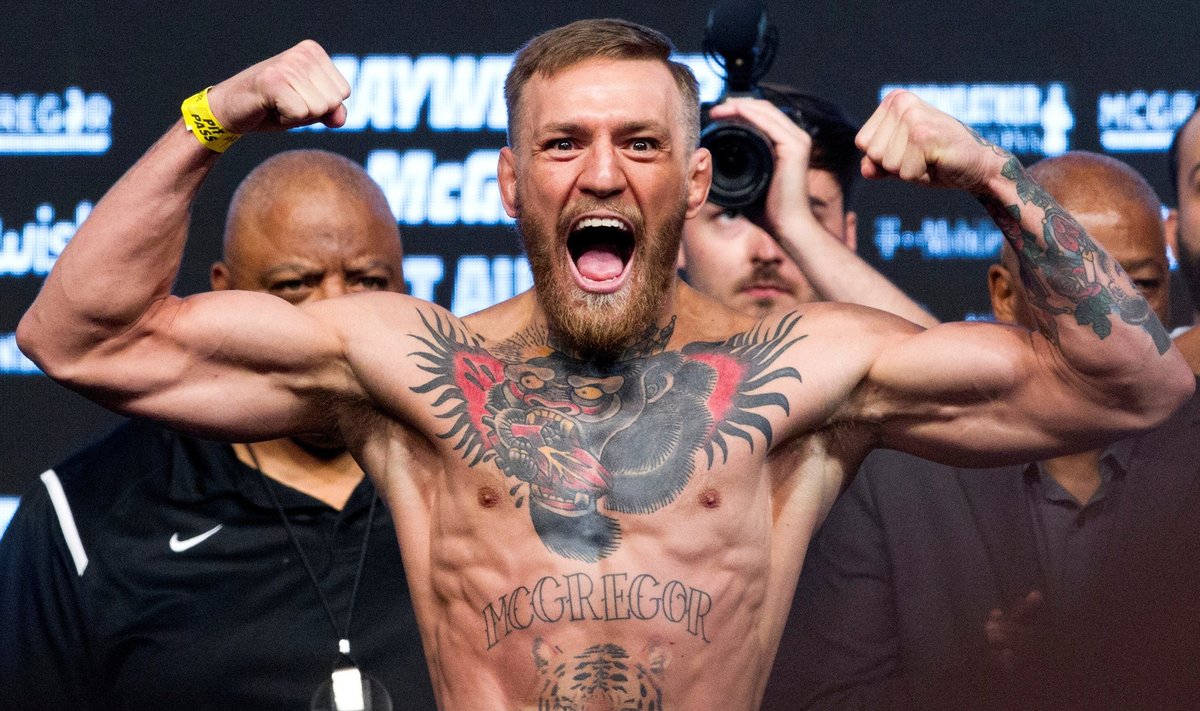 FILE PHOTO: UFC lightweight champion Conor McGregor of Ireland poses on the scale during his official weigh-in at T-Mobile Arena in Las Vegas