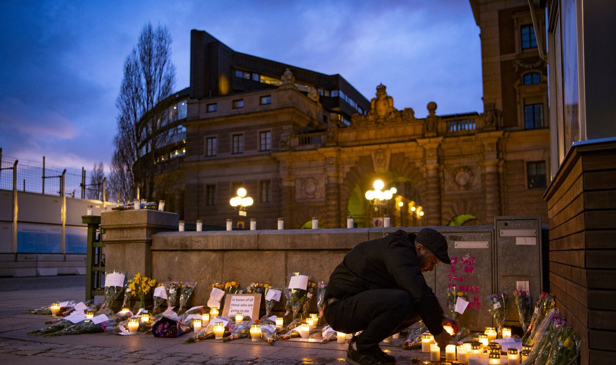 Rootslased viivad parlamendihoone ette küünlaid ja lilli koroonaviiruse ohvritele. 