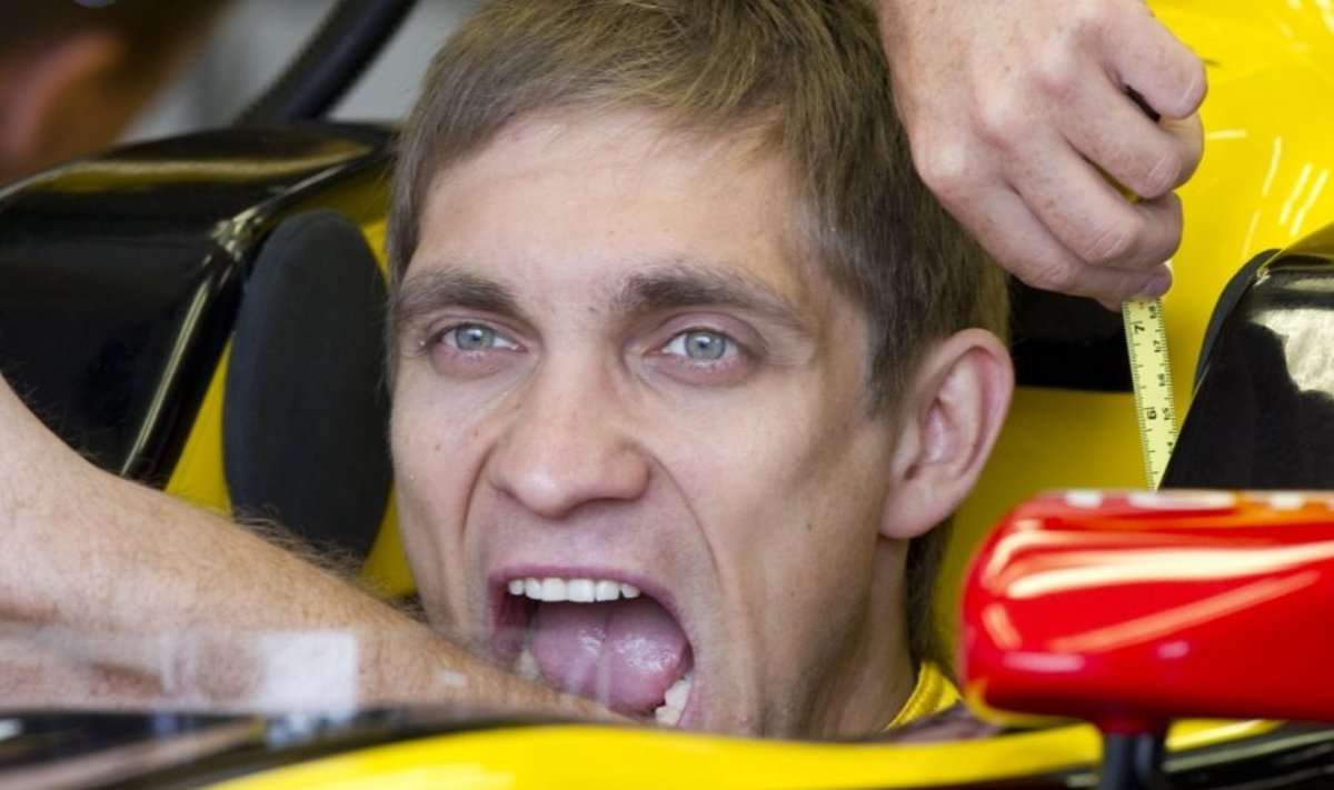 Renault driver Vitay Petrov of Russia pretends to bite the arm of a worker as he has his measurements taken in his car during practice for the Canadian Formula One Grand Prix June 11, 2010 in Montreal. AFP PHOTO/DON EMMERT
