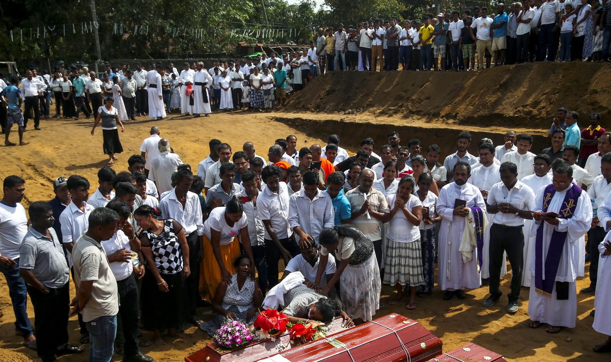 People react during a mass burial of victims, two days after a string of suicide bomb attacks on churches and luxury hotels across the island on Easter Sunday, at a cemetery near St. Sebastian Church in Negombo